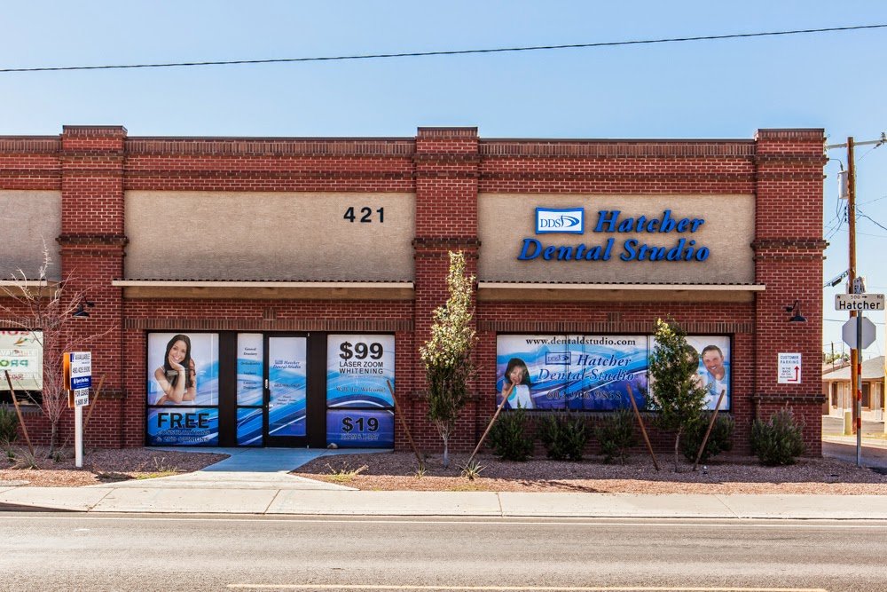 Exterior view of a brick-front dental office building with illuminated signage and glass storefront windows