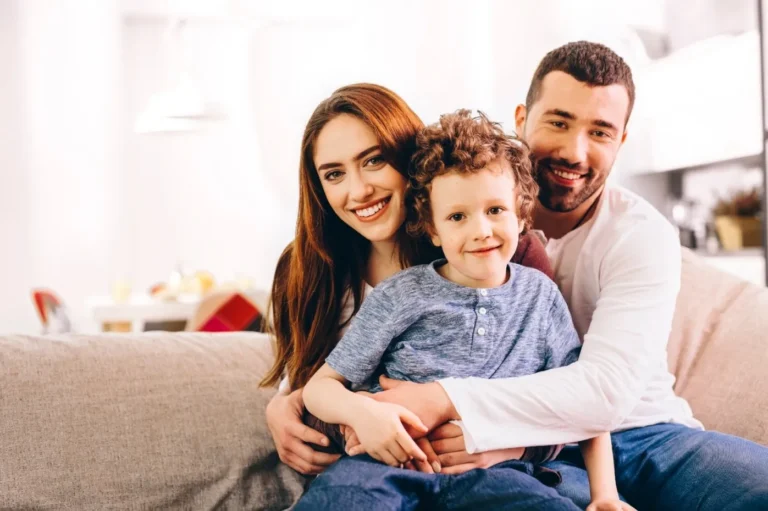 Smiling family portrait with parents and child used for patient-focused dental marketing imagery