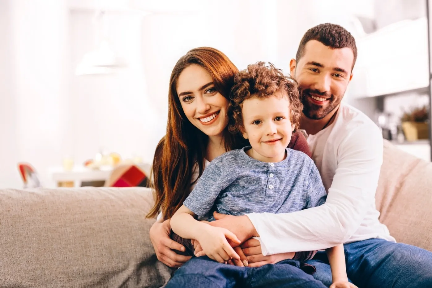 Smiling family portrait with parents and child used for patient-focused dental marketing imagery