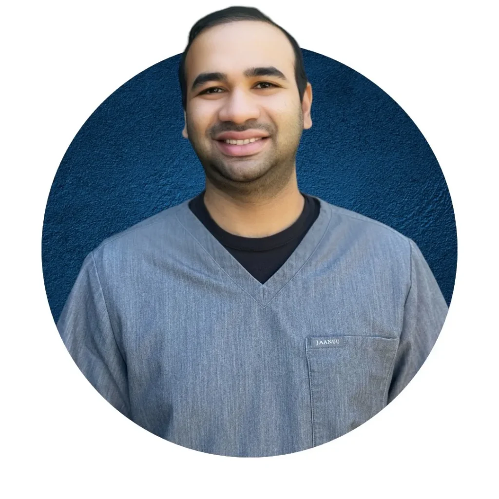 Professional headshot of a smiling dental team member in blue scrubs against a solid blue background