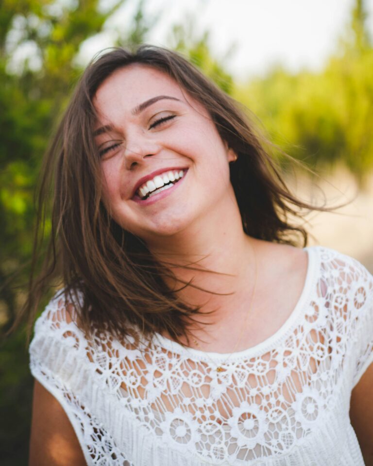 Smiling woman outdoors in a casual portrait used for patient-focused dental marketing imagery