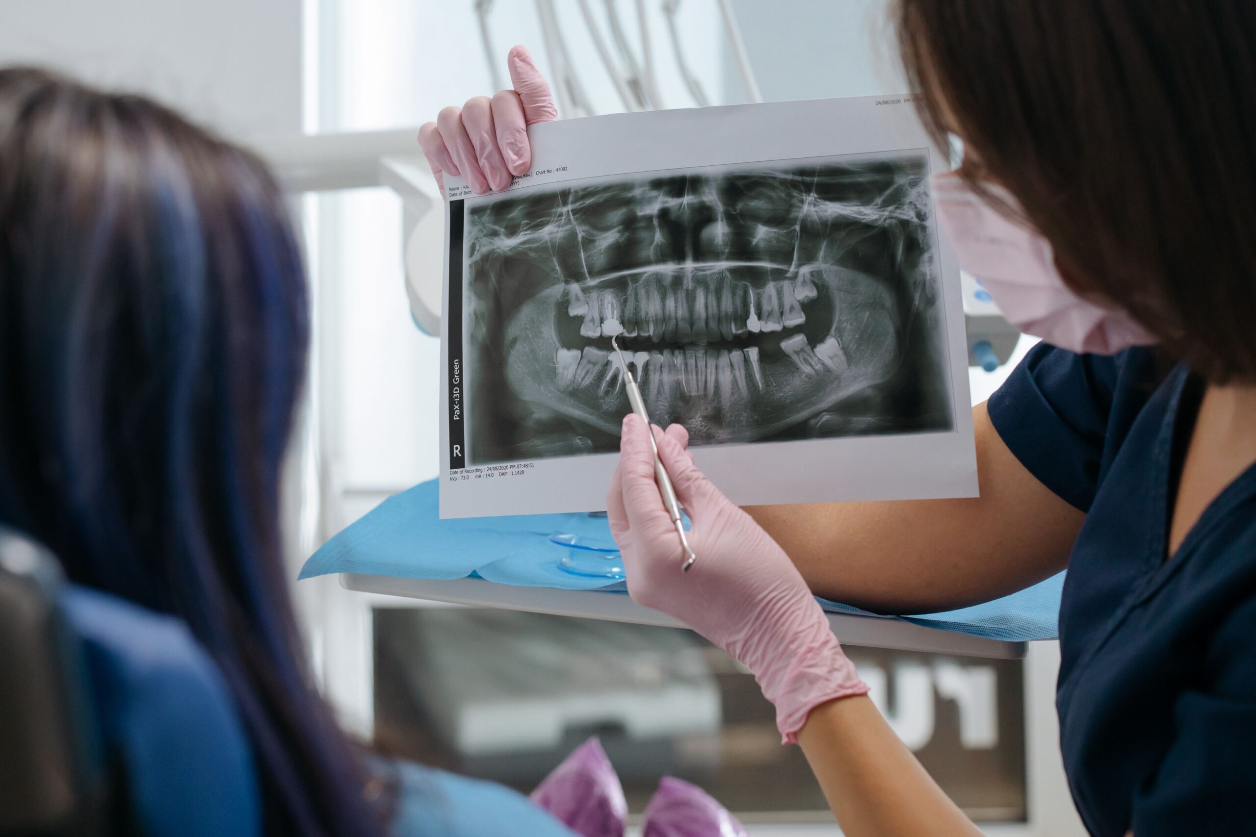 dentist reviewing a dental X-ray with a patient during a dental implant follow-up visit
