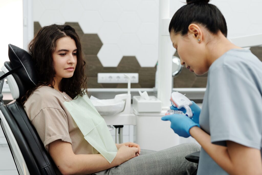 Dentist explaining a dental model to a patient during a consultation about mouth guards and night guards.