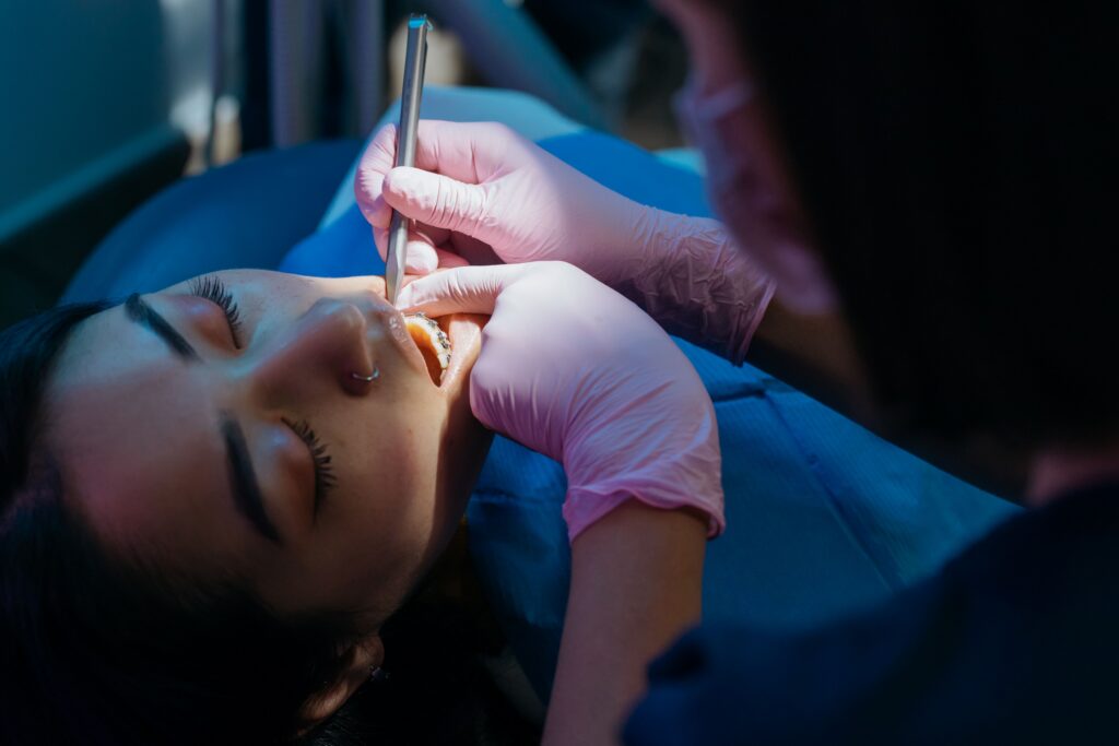 dentist examining a patient's mouth and teeth during a routine oral health screening